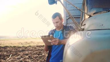 智慧农业。 男子农民司机站在卡车附近的数字平板电脑。 慢动作生活方式视频。 肖像